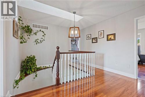 Hardwood flooring, painted white walls, white trim, wood and white spindle railing, and a vaulted ceiling with a skylight - 260 Granite Hill Road, Cambridge, ON 