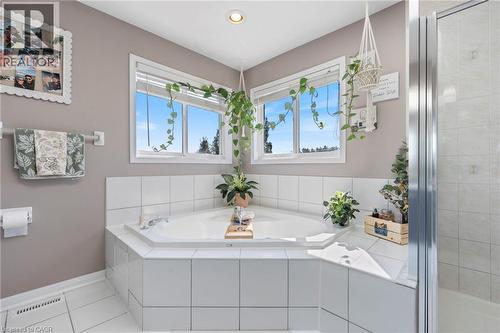 Corner soaking tub with white tile surround, white tile flooring, and integrated shower enclosure - 260 Granite Hill Road, Cambridge, ON 