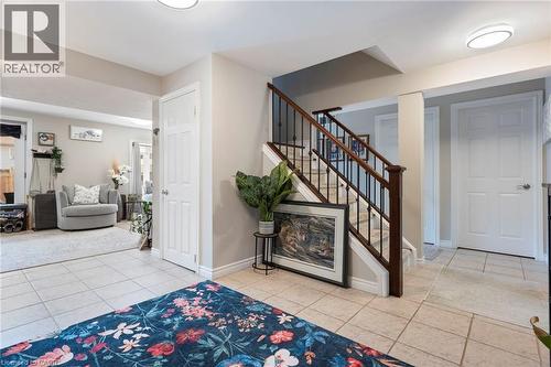 Tiled flooring, staircase with wood-finish handrails and black metal spindles, built-in lighting, paneled doors, and neutral wall tones - 260 Granite Hill Road, Cambridge, ON 