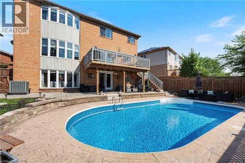 Brick exterior with a multi-level deck, ground-level patio, and built-in swimming pool - 260 Granite Hill Road, Cambridge, ON 