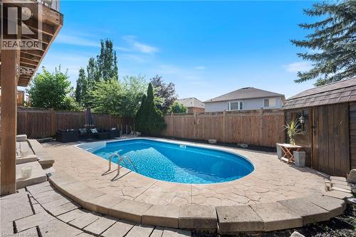 Outdoor swimming pool with integrated steps, surrounded by stone-finish coping and a stone-finish patio - 260 Granite Hill Road, Cambridge, ON 