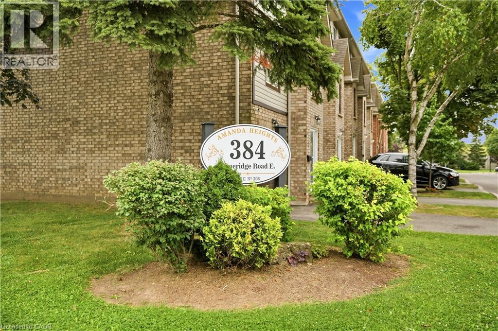 Brick exterior with pitched rooflines and adjacent parking area - 384 Limeridge Road E Unit# 16, Hamilton, ON