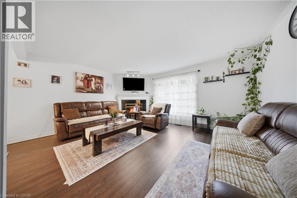 Wood-finish flooring, white walls, and a fireplace with a white mantel and hearth - 384 Limeridge Road E Unit# 16, Hamilton, ON