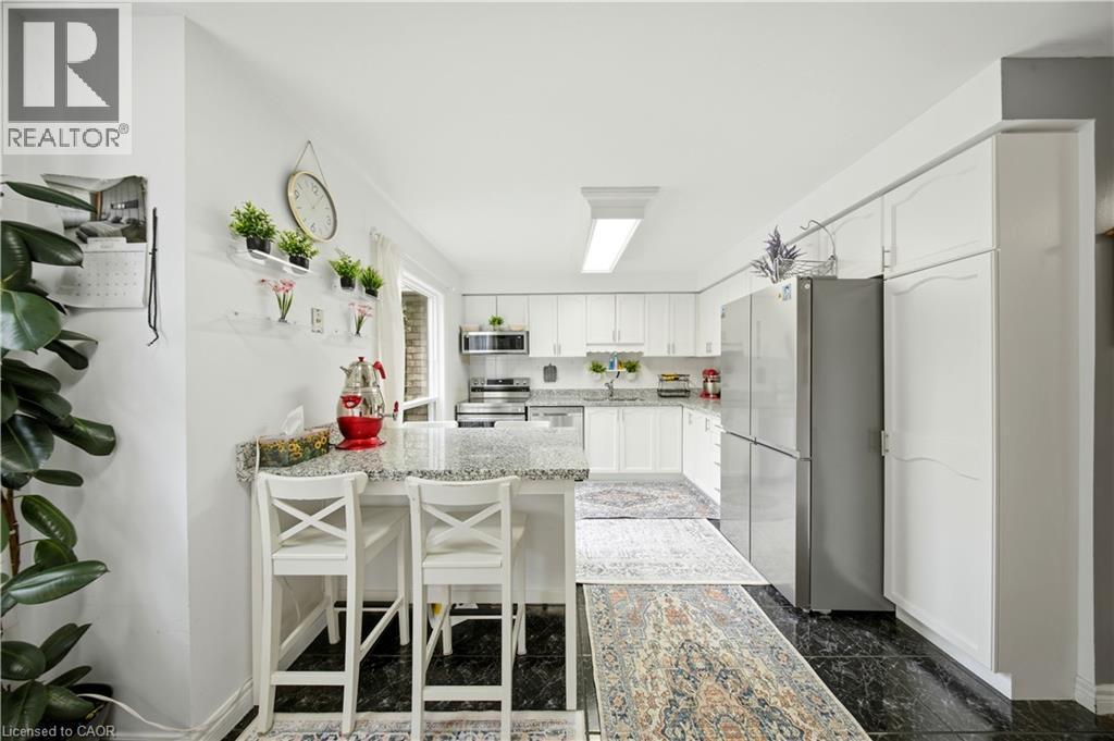 White cabinetry with extensive storage, stainless steel appliances, and a light-toned countertop - 384 Limeridge Road E Unit# 16, Hamilton, ON