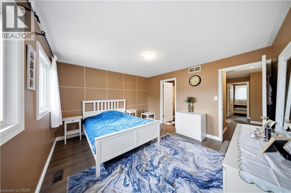 Wood-finish flooring throughout, two windows with white trim, and a built-in overhead light fixture - 384 Limeridge Road E Unit# 16, Hamilton, ON