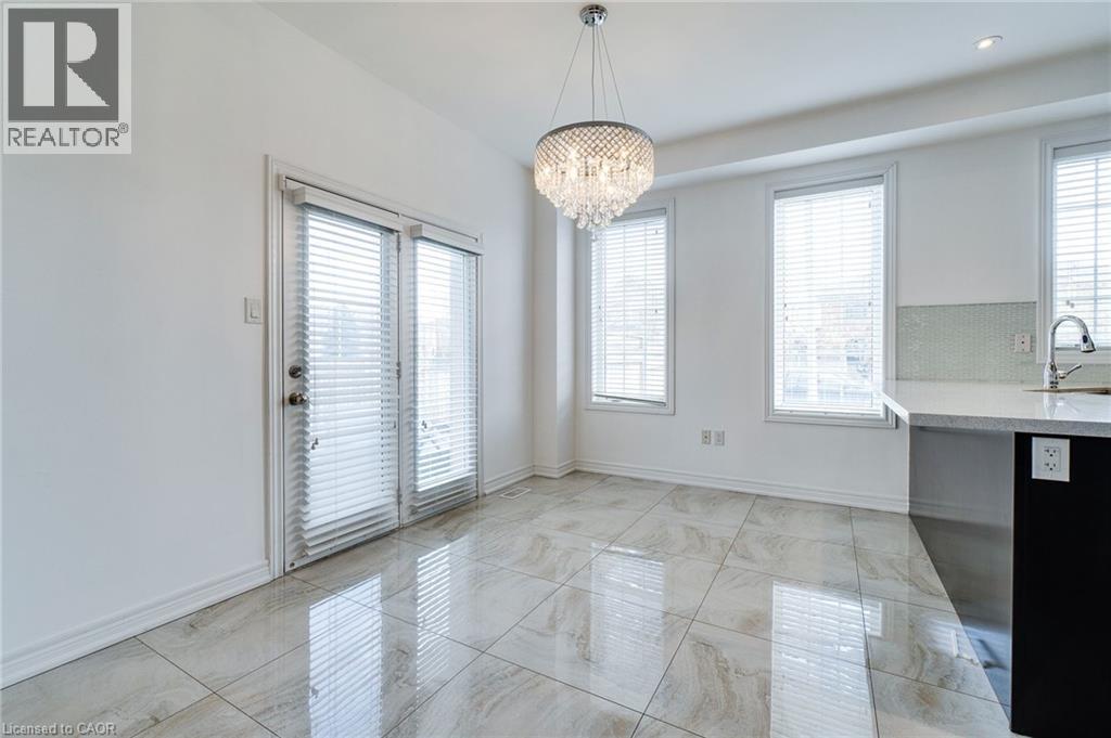Hard-surface tile flooring, double glass panel door, three windows, a crystal chandelier, and a partial kitchen counter with a tile backsplash - 2 Hawstone Road, Vellore, ON