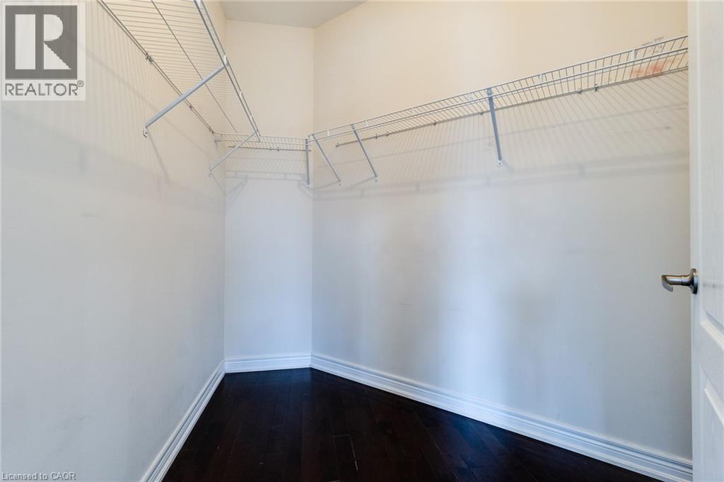 Walk-in closet with dark wood-finish flooring and wire shelving - 2 Hawstone Road, Vellore, ON