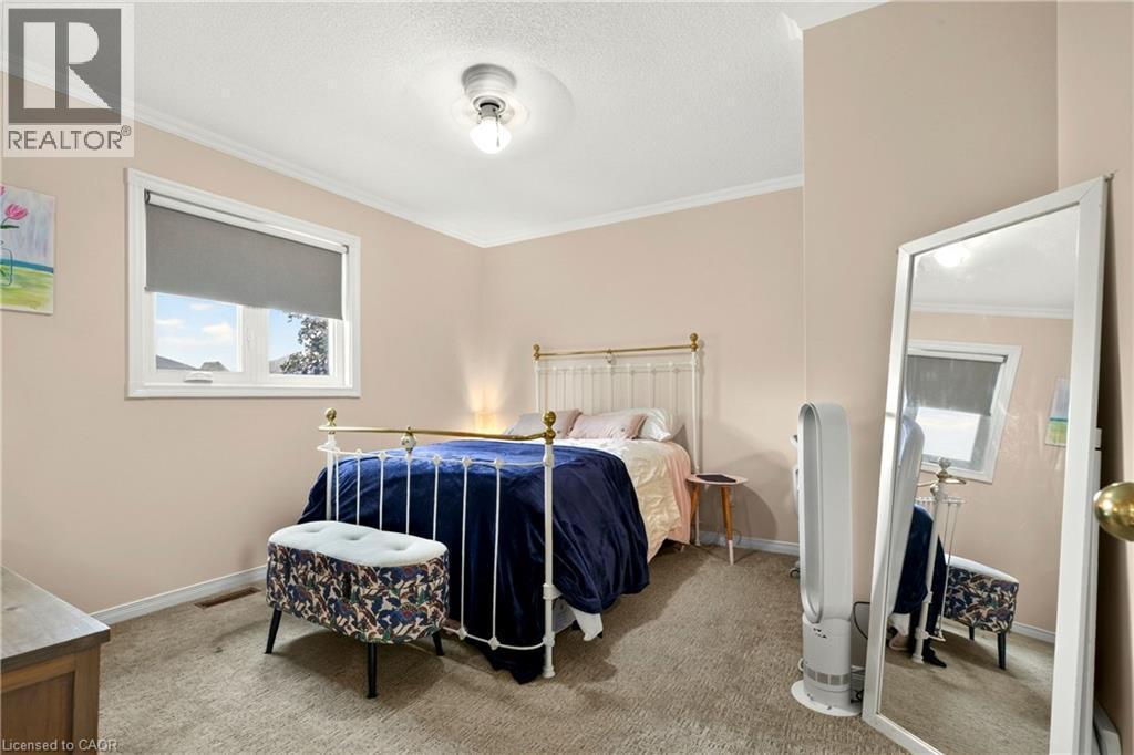 Textured carpeting, crown molding, and a single window with roller shade - 31 Grindstone Way, Hamilton, ON
