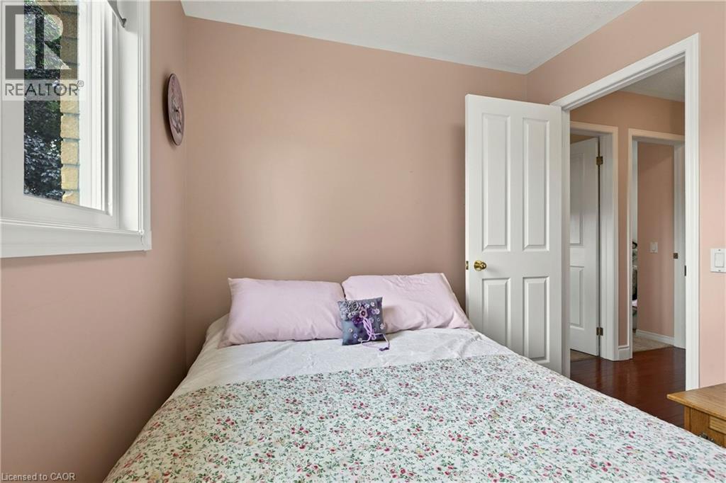 White trim window, light-toned walls, and wood-finish flooring - 31 Grindstone Way, Hamilton, ON