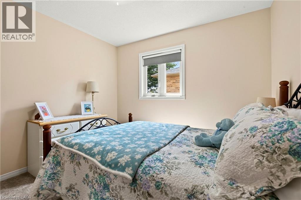 Neutral wall paint, window with roller shade, textured ceiling, and carpet flooring - 31 Grindstone Way, Hamilton, ON