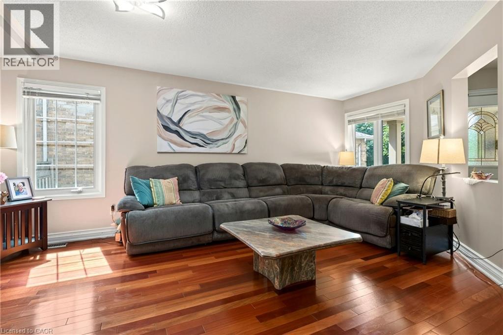 Hardwood flooring, neutral wall tones, recessed ceiling lighting, bay window, and an interior pass-through window - 31 Grindstone Way, Hamilton, ON