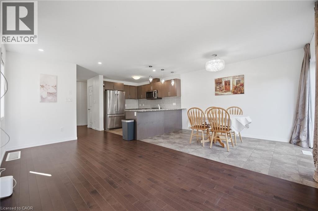Wood-finish flooring, recessed lighting, built-in kitchen cabinetry, stainless steel appliances, and a kitchen island with seating - 135 Hardcastle Drive Unit# 85, Cambridge, ON