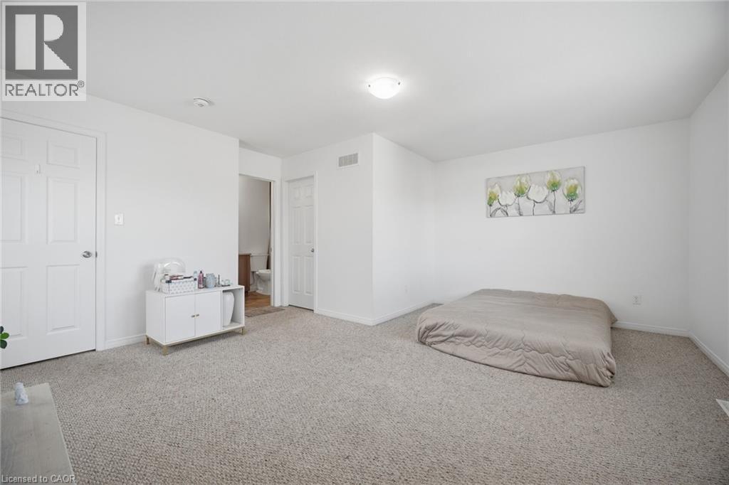 Carpeted room with white walls, white paneled doors, and an overhead flush-mount light fixture - 135 Hardcastle Drive Unit# 85, Cambridge, ON