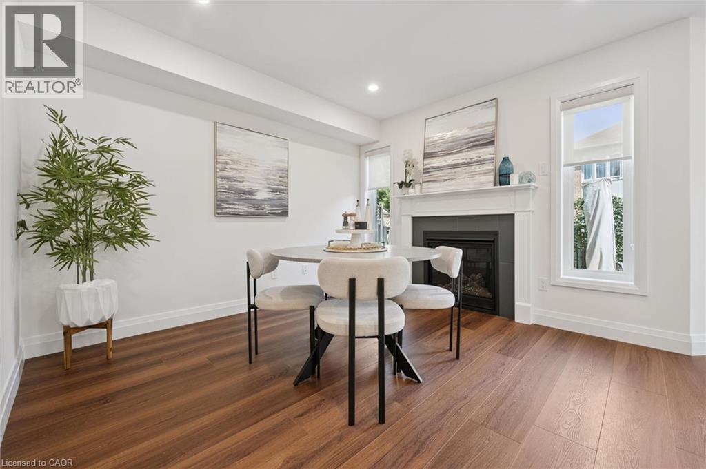 Wood-finish flooring, recessed lighting, and a prominent fireplace with a white mantel and dark surround - 2294 Seton Crescent, Burlington, ON