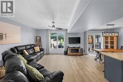 Light wood-finish flooring throughout, complemented by a modern ceiling fan and recessed lighting - 