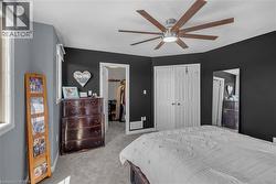 Recessed window, ceiling fan with wood-finish blades, white bi-fold closet doors, carpeted flooring, and a walk-in closet - 