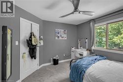 Window with exterior foliage, ceiling fan, and light gray wall paint - 