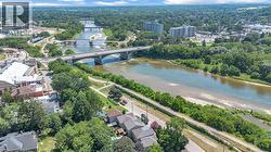 Aerial perspective showcasing a river with multiple bridges, surrounded by mature trees and urban structures - 