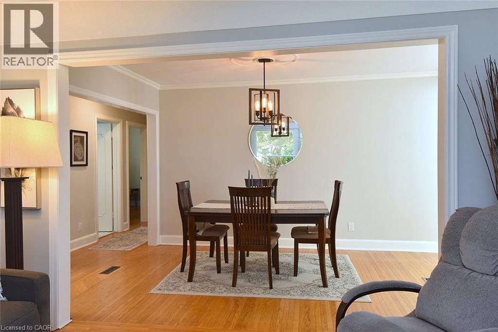 Hardwood flooring throughout, crown molding, and a modern rectangular chandelier - 936 Boothman Avenue, Burlington, ON