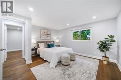 Recessed lighting, wood-finish flooring, white trim, and a window with exterior views - 