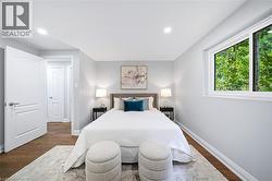 Recessed lighting, wood-finish flooring, white trim, and a window with a green exterior - 