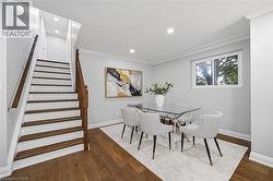 Hardwood flooring, painted risers, wood staircase with banister, crown molding, and recessed lighting - 