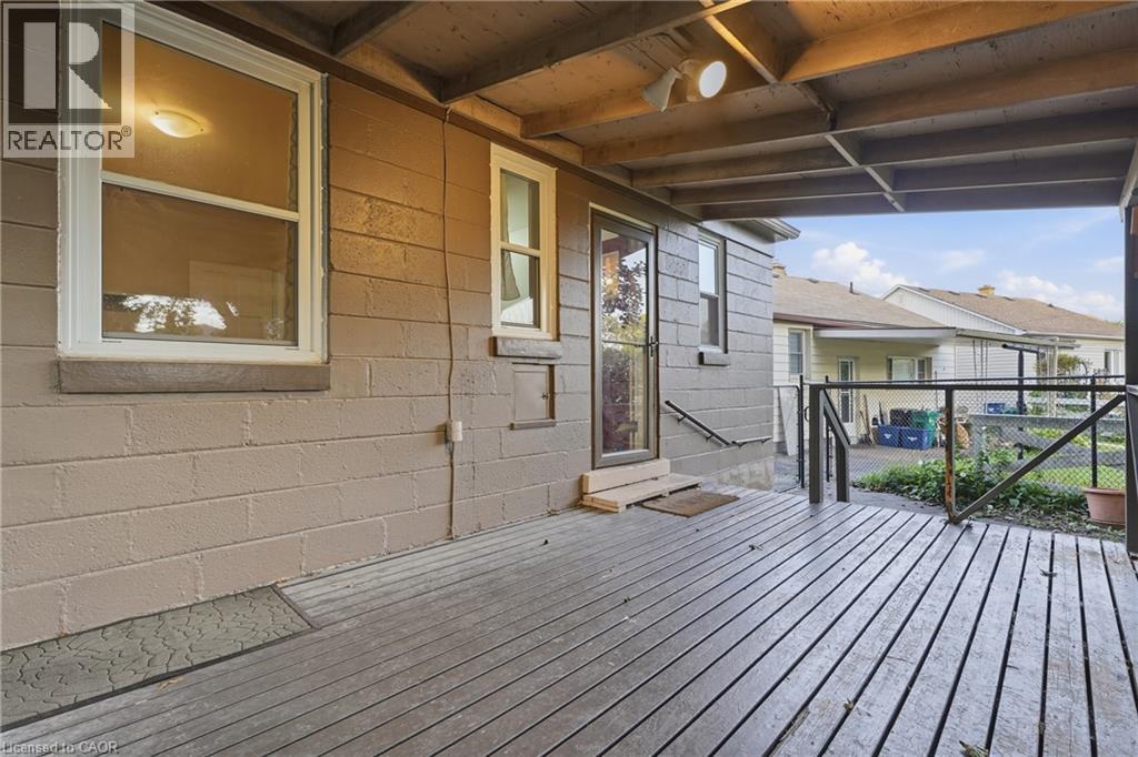 Covered outdoor deck with wooden flooring and a screened door access - 160 Lorne Crescent, Kitchener, ON
