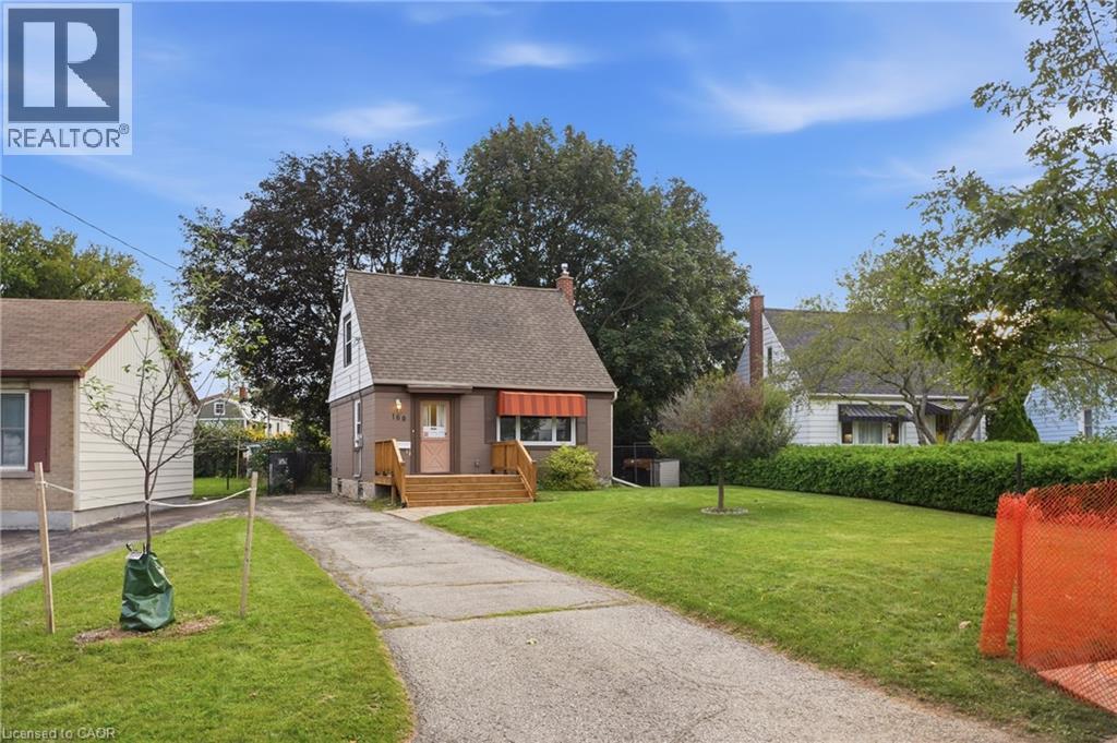 Gable roofline residence with a wood deck entry and a front yard with mature landscaping - 160 Lorne Crescent, Kitchener, ON