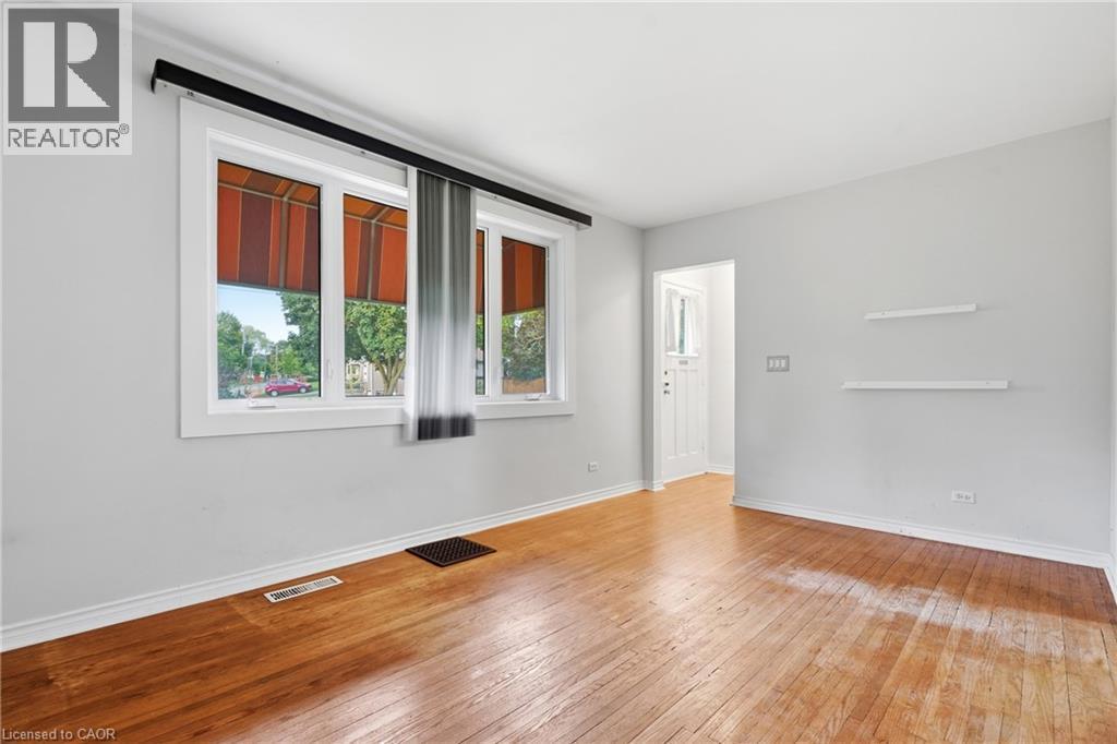 Hardwood flooring throughout, white trim, dual windows, and a white paneled entry door - 160 Lorne Crescent, Kitchener, ON