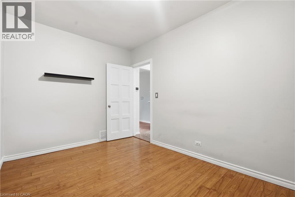 Wood-finish flooring, white paneled door, and white painted walls - 160 Lorne Crescent, Kitchener, ON