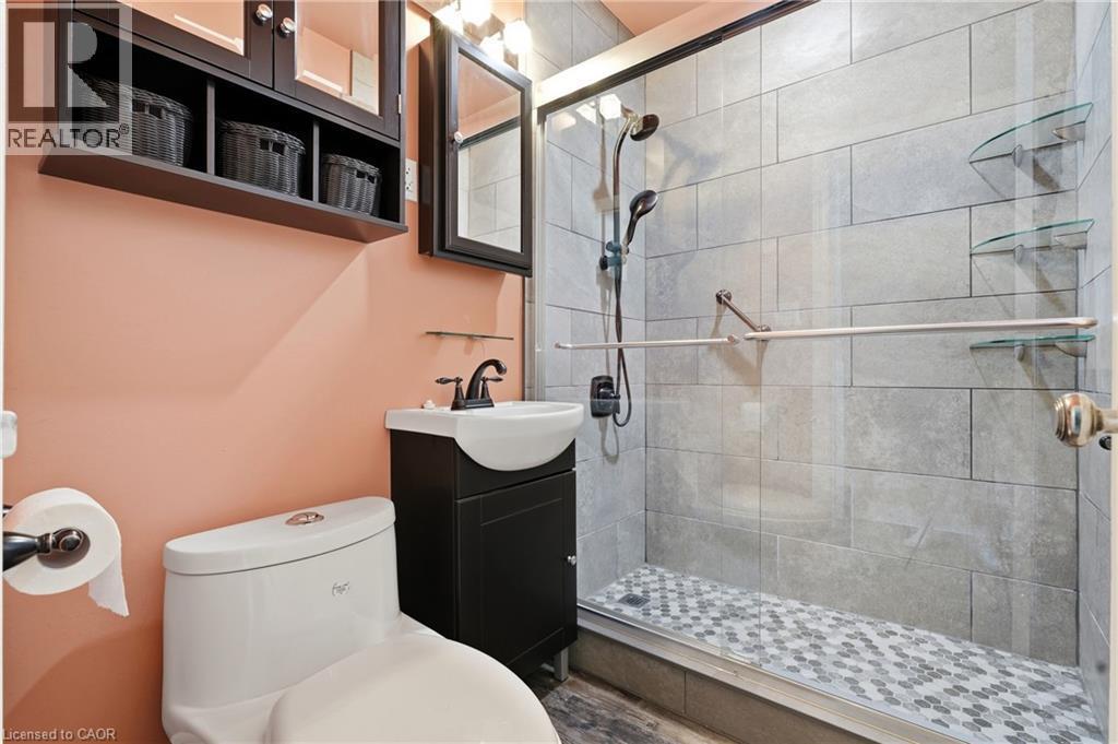 Full glass shower enclosure with gray tile surround and mosaic floor - 160 Lorne Crescent, Kitchener, ON