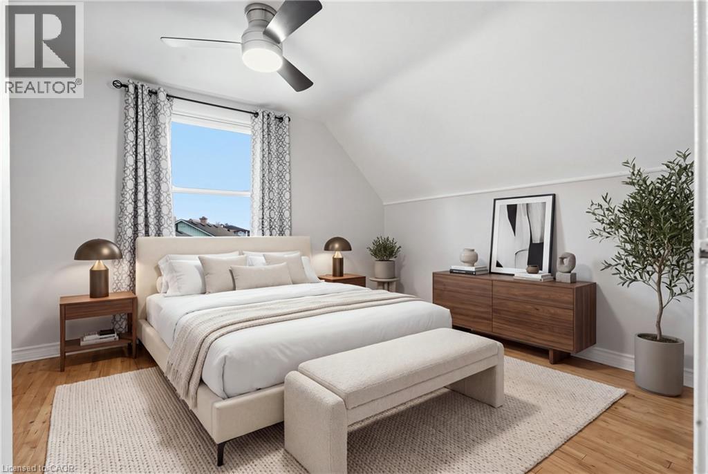 Sloped ceiling accentuating the room's height, wood-finish flooring, and a ceiling fan with integrated lighting - 160 Lorne Crescent, Kitchener, ON