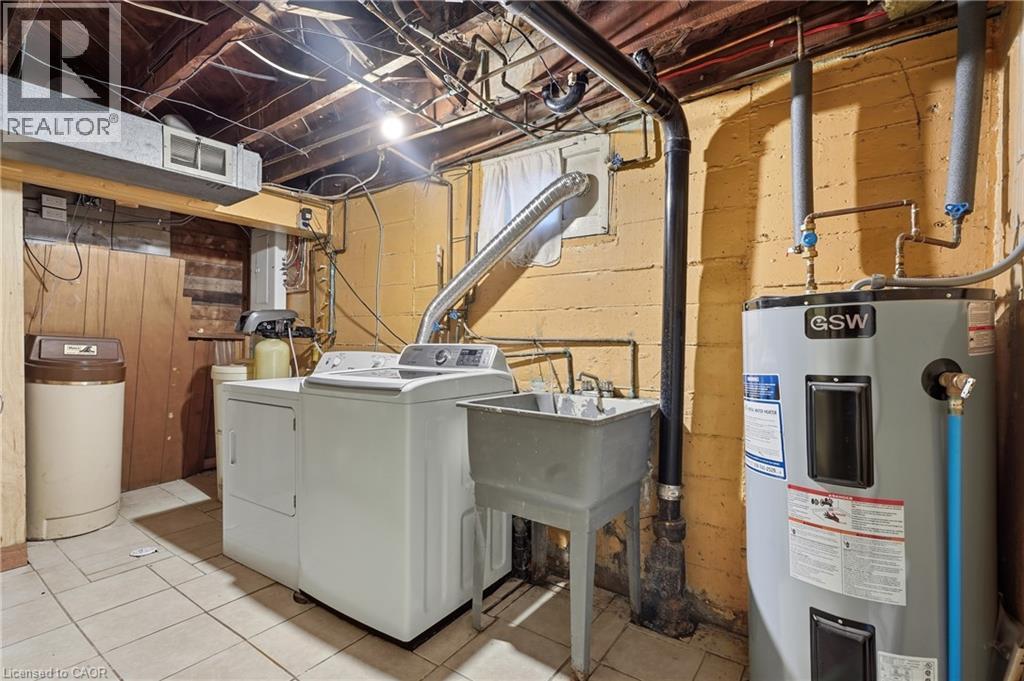 Utility area featuring a water heater, laundry appliances, a laundry sink, and tile flooring - 160 Lorne Crescent, Kitchener, ON