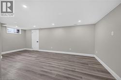 Recessed lighting illuminates the spacious room with wood-finish flooring - 