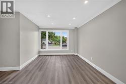 Recessed lighting, light gray walls, wood-finish flooring, white trim, and a large multi-pane window - 