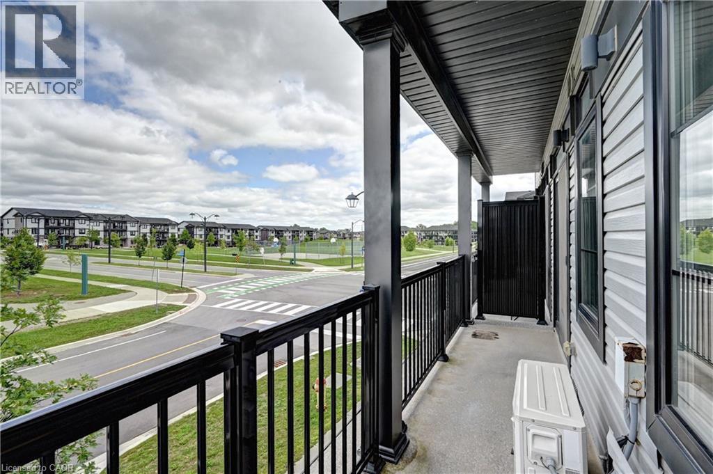 Balcony featuring black metal railings and overhead soffit - 102 Wheat Lane, Kitchener, ON