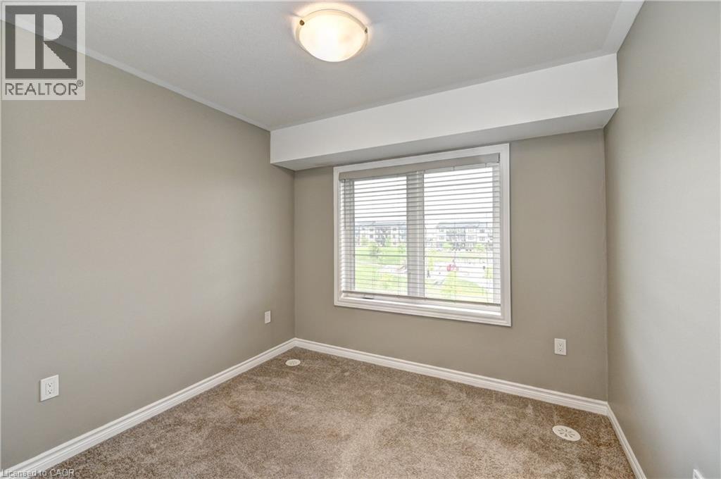 Neutral-toned walls, carpeted flooring, window with horizontal blinds, flush mount ceiling light fixture, white trim - 102 Wheat Lane, Kitchener, ON