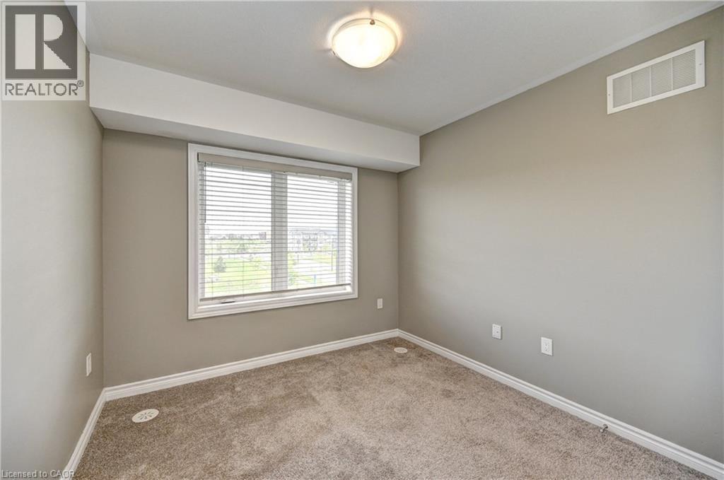 Wall-to-wall carpeting, neutral wall color, white trim, and a window with blinds - 102 Wheat Lane, Kitchener, ON