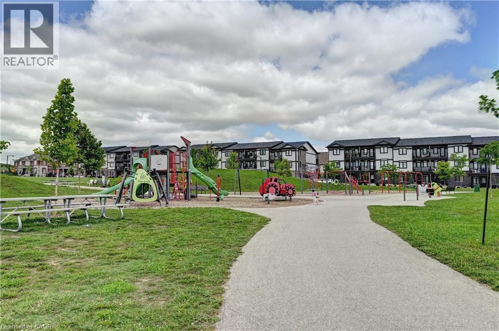 Community park area featuring recreational equipment and paved walking paths - 102 Wheat Lane, Kitchener, ON