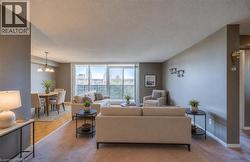 Living area with a textured ceiling, light colored carpet, and a chandelier Staged using AI - 