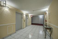 Corridor with wainscoting, a decorative wall, elevator, a textured ceiling, and a textured wall - 