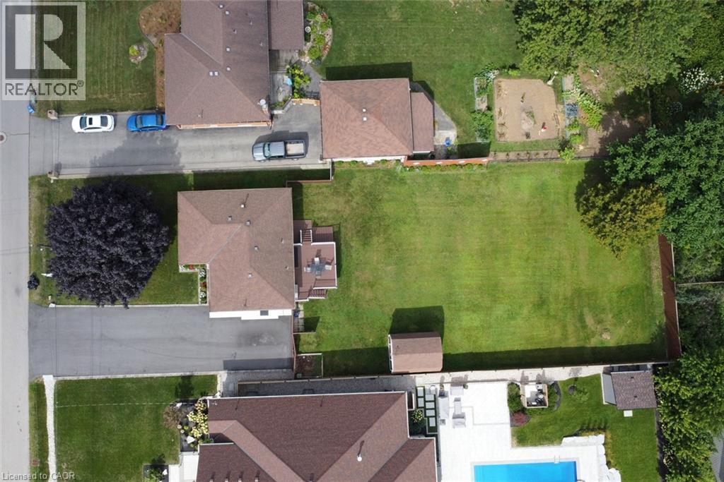Aerial view showcasing a substantial residential lot with manicured lawn, mature landscaping, and brick exterior architecture - 98 Kennedy Avenue, Hamilton, ON