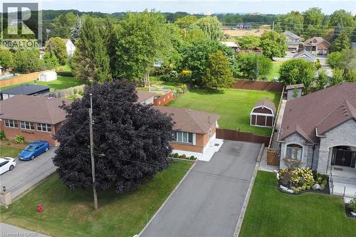 Spacious residential property featuring a brick ranch-style home with an attached garage, situated on a manicured lot with mature landscaping - 98 Kennedy Avenue, Hamilton, ON 