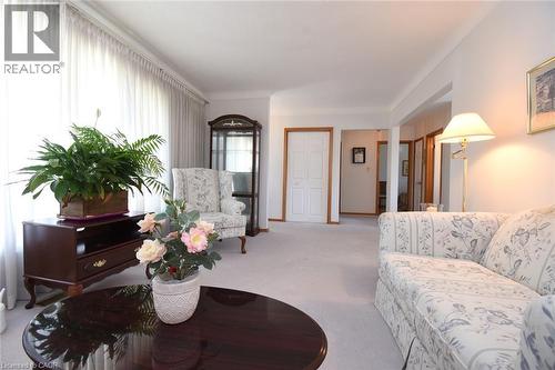 Elegant foyer showcasing neutral carpeting, crown molding, and abundant natural light from sheer-draped windows - 98 Kennedy Avenue, Hamilton, ON 
