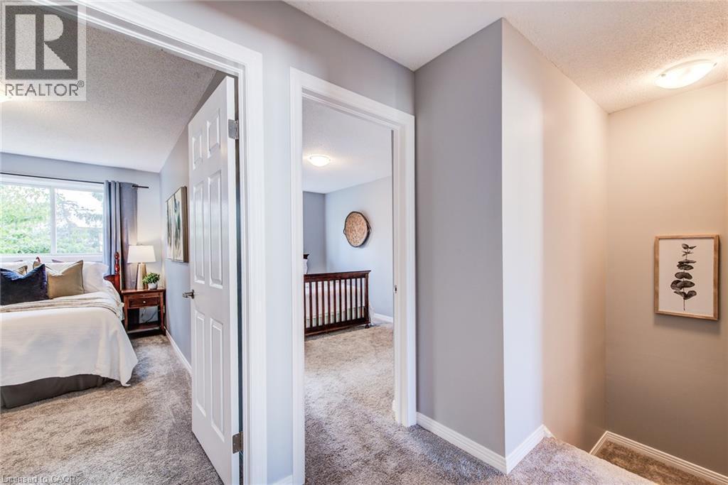 Carpeted flooring throughout, neutral painted walls, and white trim accents - 360 Cornridge Place Unit# 2, Waterloo, ON