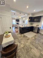 Kitchen featuring dark cabinetry, light-colored countertops, stainless steel appliances, and pendant lighting - 
