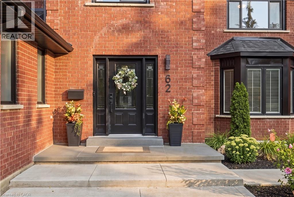 Brick facade with decorative banding, black-framed windows, and a black front entry door with sidelights - 62 Corfield Drive, Kitchener, ON