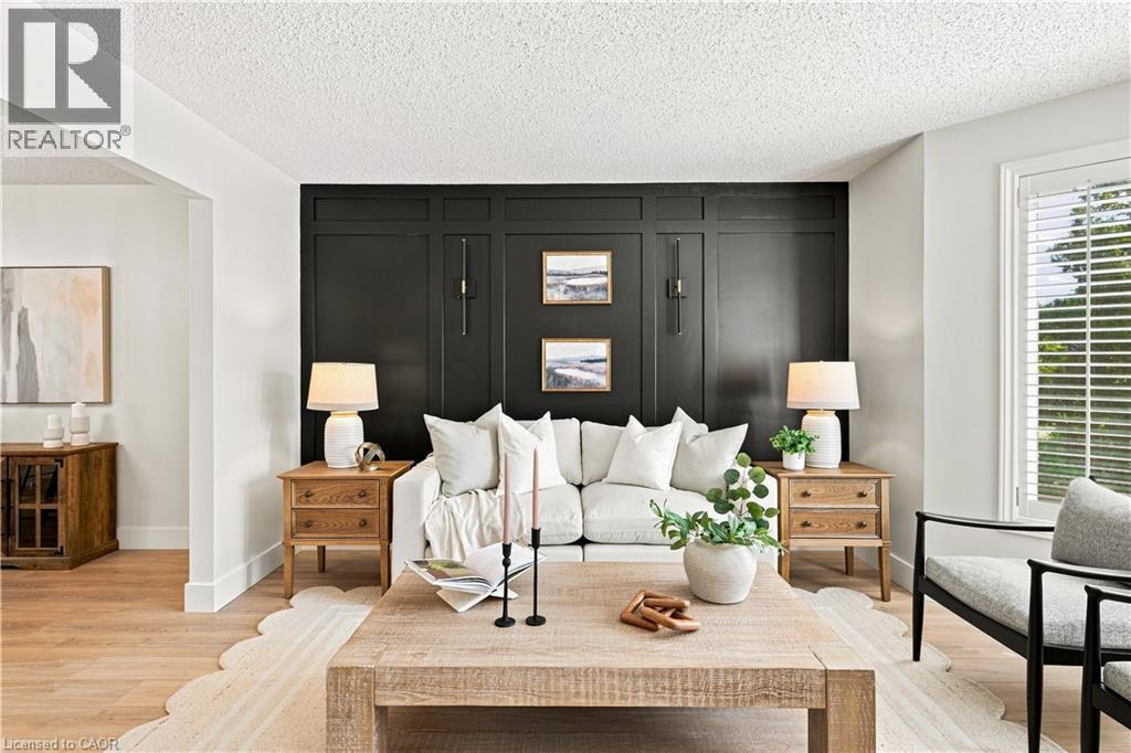 Accent wall with wainscoting detail, wood-finish flooring, and white window blinds - 62 Corfield Drive, Kitchener, ON