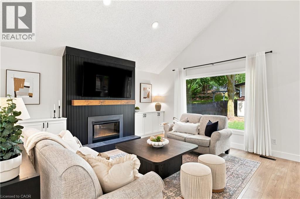 Vaulted ceiling, fireplace with wood mantel, built-in cabinetry, large window, wood-finish flooring - 62 Corfield Drive, Kitchener, ON