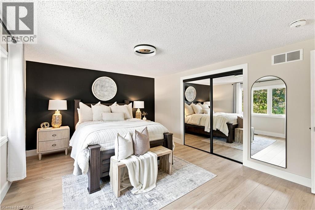 Wood-finish flooring, mirrored closet doors, and recessed lighting - 62 Corfield Drive, Kitchener, ON